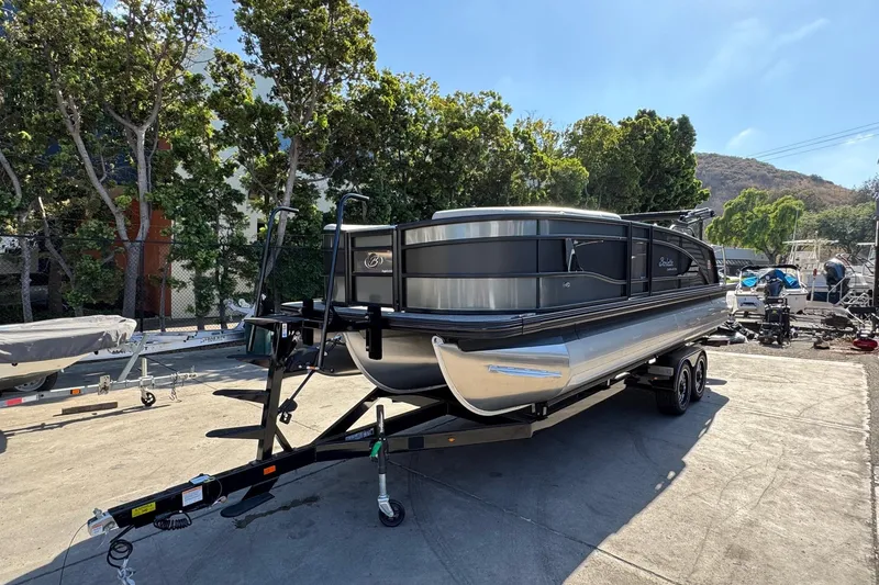 Slide: The Image of 2026 Barletta Lusso 23UC pontoon boat on trailer, parked outdoors. - 120