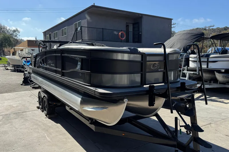 Slide: The Image of 2026 Barletta Lusso 23UC pontoon boat on trailer, parked outdoors. - 122
