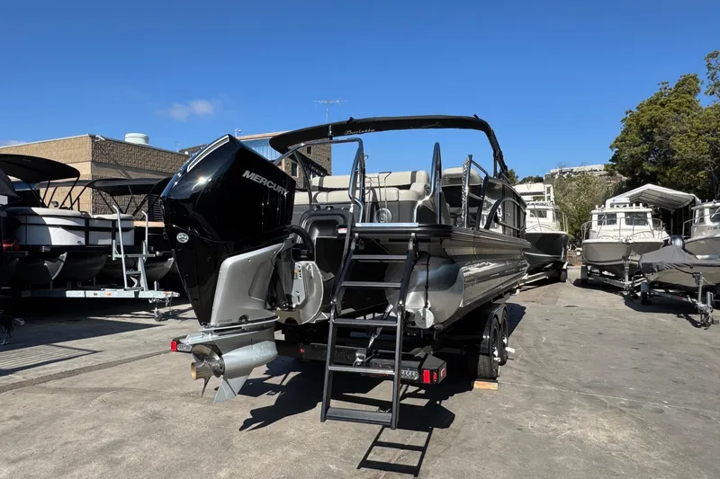 Slide: The Image of 2026 Barletta Lusso 23UC pontoon boat with Mercury engine, parked outdoors. - 129