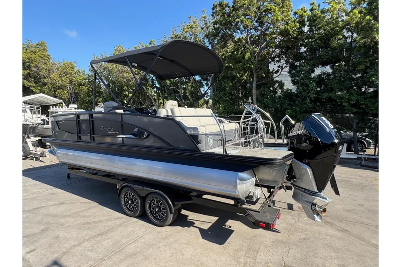 Slide: The Image of 2026 Barletta Lusso 23UC pontoon boat on trailer, parked outdoors. - 175