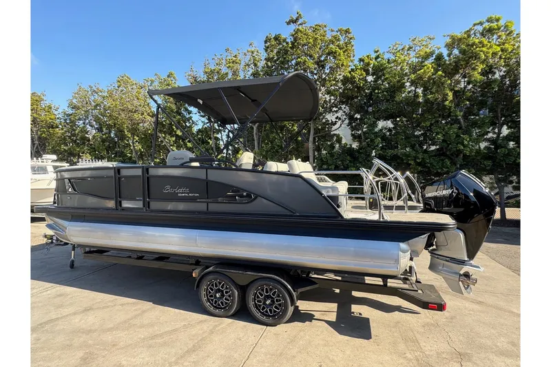 Slide: The Image of 2026 Barletta Lusso 23UC pontoon boat on trailer, parked outdoors. - 176