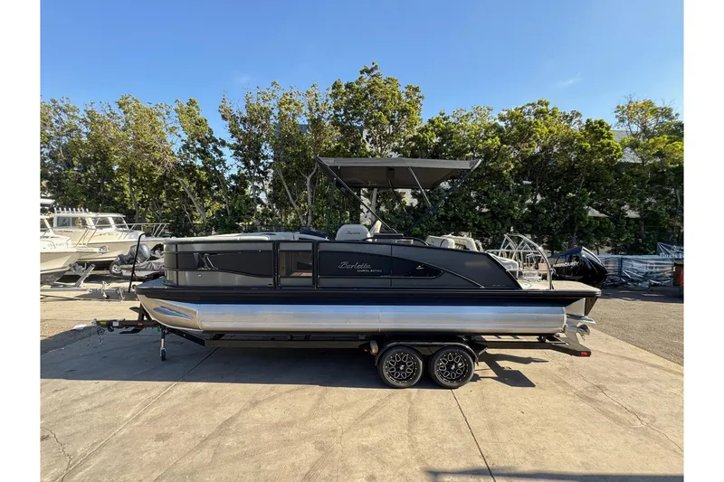 Slide: The Image of 2026 Barletta Lusso 23UC pontoon boat on trailer, parked outdoors. - 178