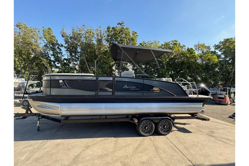 Slide: The Image of 2026 Barletta Lusso 23UC pontoon boat on trailer, parked outdoors. - 179