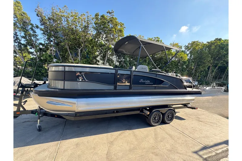 Slide: The Image of 2026 Barletta Lusso 23UC pontoon boat on trailer, parked outdoors. - 180