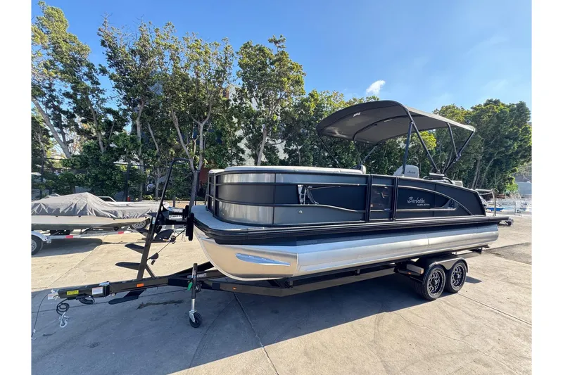 Slide: The Image of 2026 Barletta Lusso 23UC pontoon boat on trailer, parked outdoors. - 181