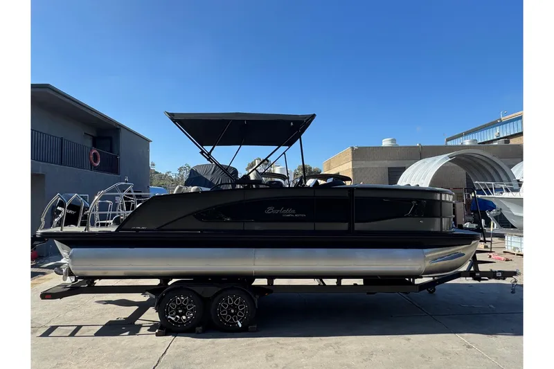 Slide: The Image of 2026 Barletta Lusso 23UC pontoon boat on trailer, parked outdoors. - 185