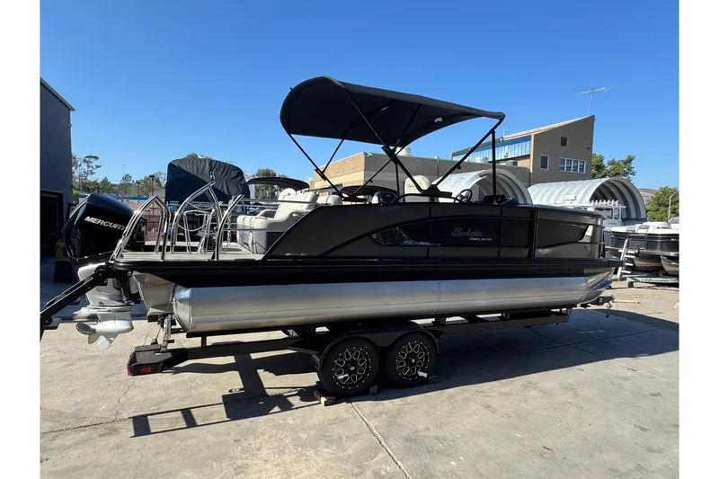 Slide: The Image of 2026 Barletta Lusso 23UC pontoon boat on trailer, featuring sleek design and Mercury outboard motor. - 186