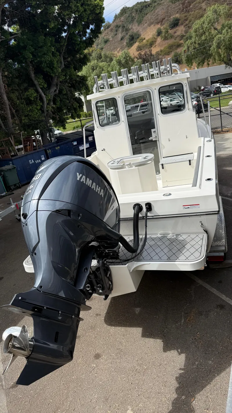 Slide: The Image of 2025 Defiance Admiral 220 EX boat with Yamaha outboard motor, parked outdoors. - 11
