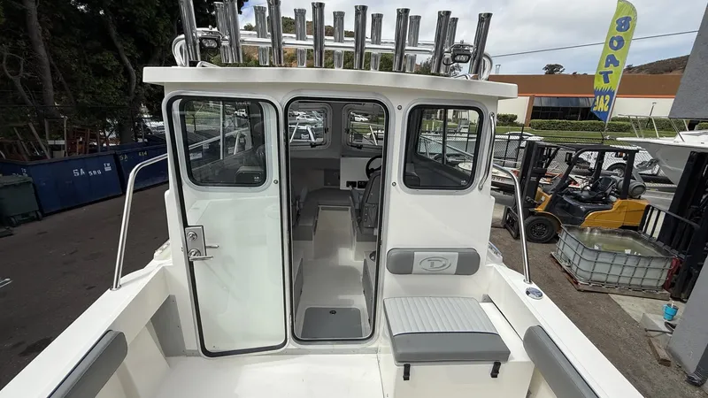 Slide: The Image of 2025 Defiance Admiral 220 EX boat interior with seating and rod holders, displayed at a sale event. - 17