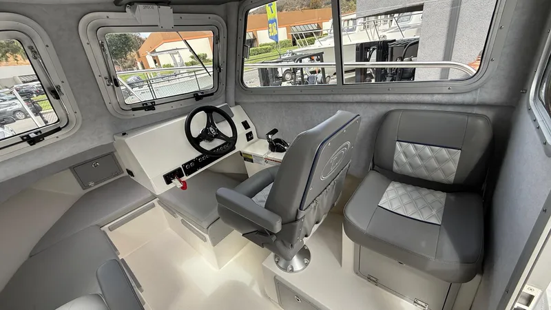 Slide: The Image of Interior of 2025 Defiance Admiral 220 EX boat, featuring steering wheel and seating. - 21