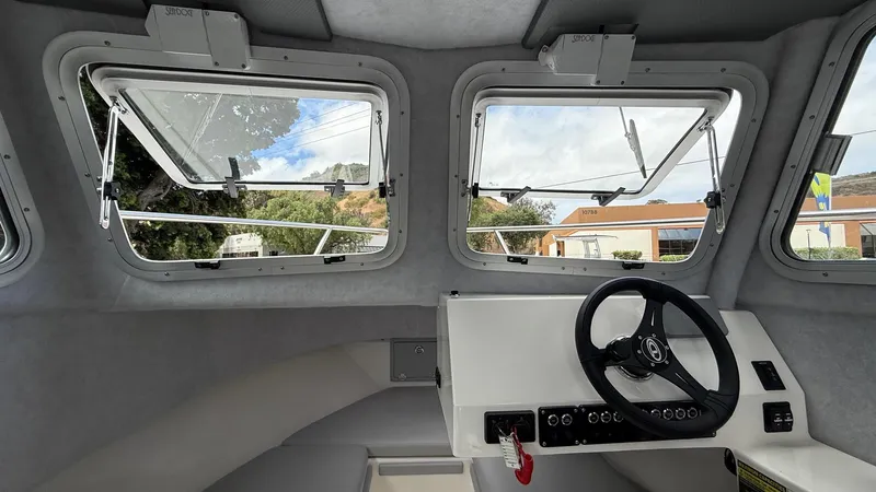 Slide: The Image of Interior view of 2025 Defiance Admiral 220 EX boat cockpit with steering wheel and windows. - 22