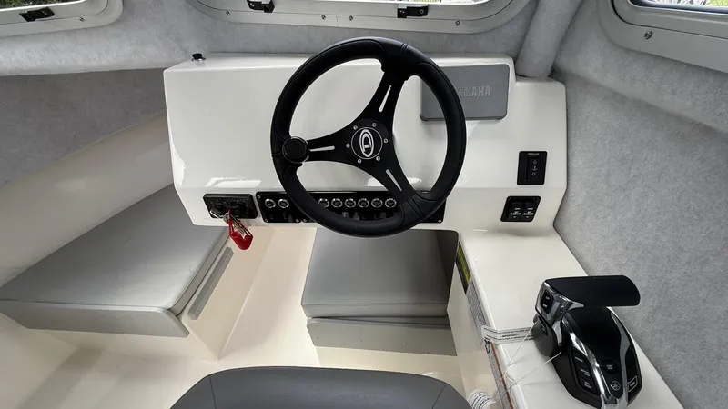 Slide: The Image of Interior of 2025 Defiance Admiral 220 EX boat, featuring steering wheel and control panel. - 23