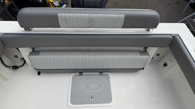 Slide: The Image of 2025 Defiance Admiral 220 EX boat seating and storage compartment, featuring gray cushioned seats. - 27