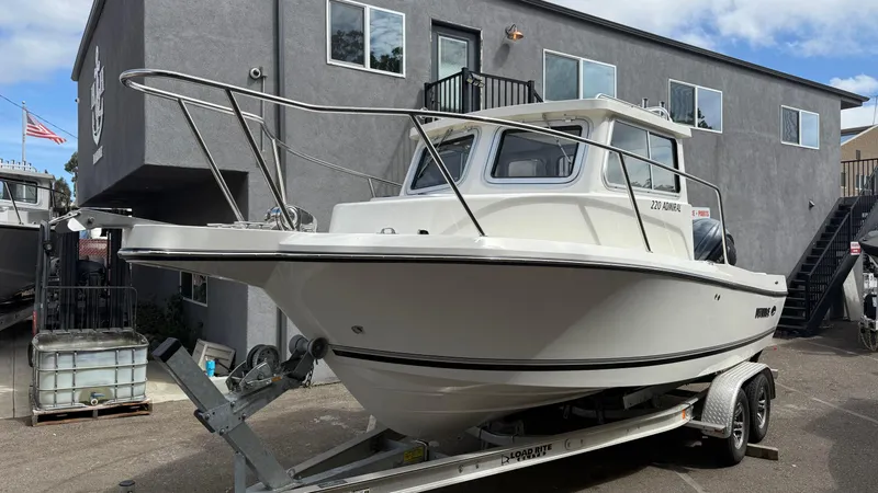 Slide: The Image of 2025 Defiance Admiral 220 EX boat on trailer, parked outside a building. - 3