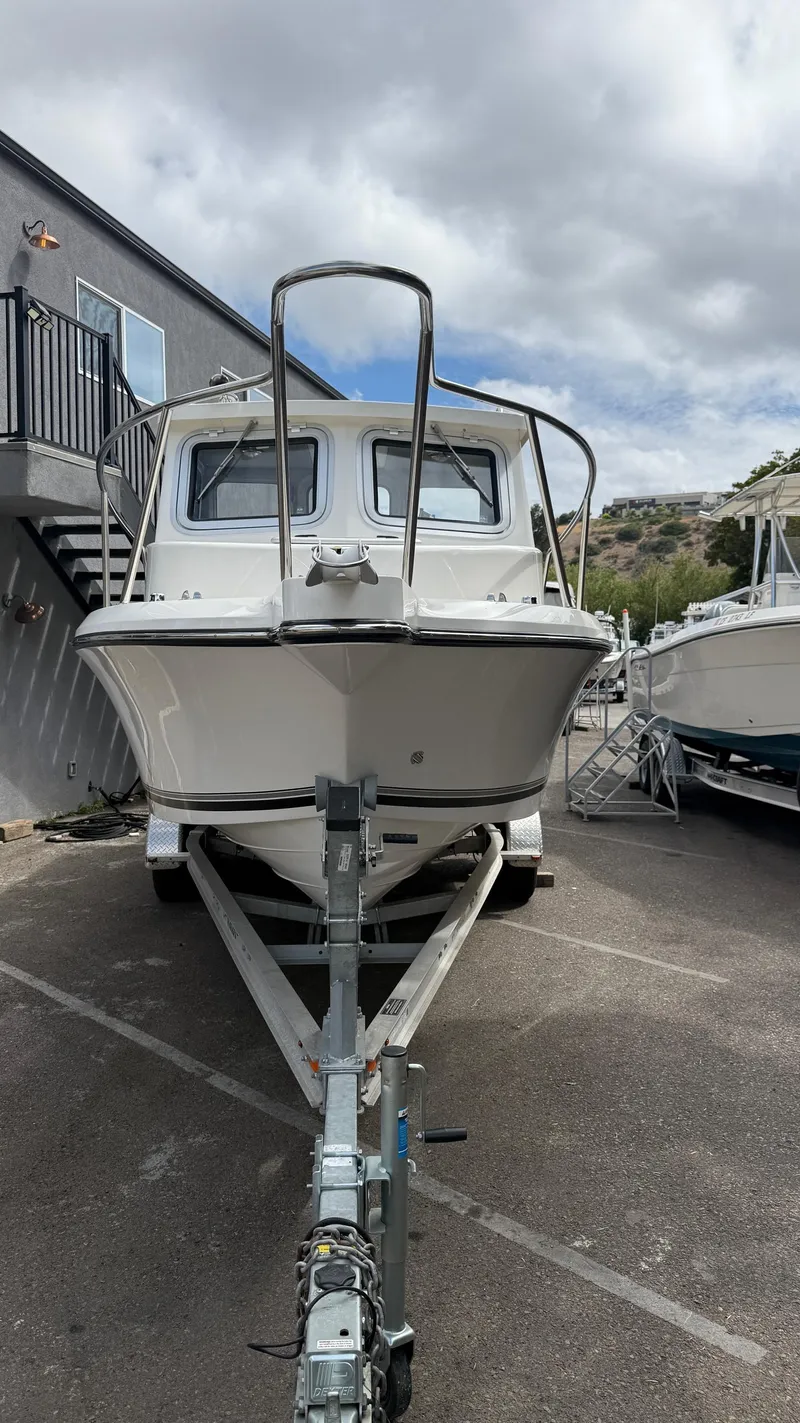 Slide: The Image of 2025 Defiance Admiral 220 EX boat on trailer, parked outdoors under cloudy sky. - 5