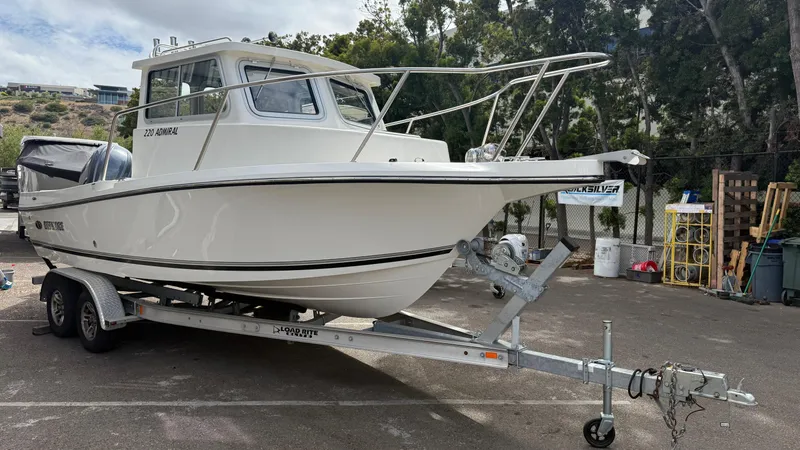 Slide: The Image of 2025 Defiance Admiral 220 EX boat on trailer, parked outdoors. - 7