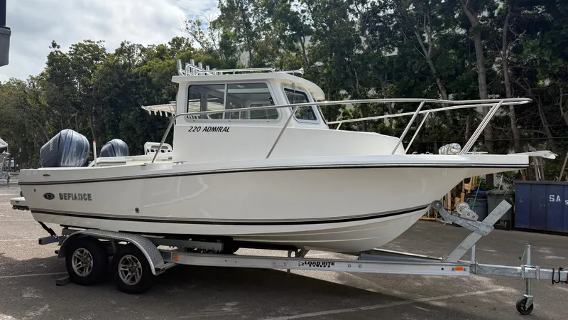 Slide: The Image of 2025 Defiance Admiral 220 EX boat on trailer, parked outdoors. - 8