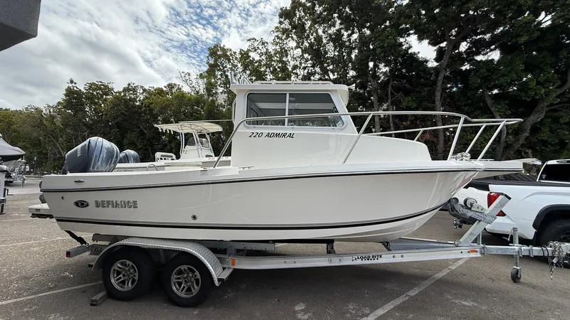 Slide: The Image of 2025 Defiance Admiral 220 EX boat on trailer, parked outdoors. - 9