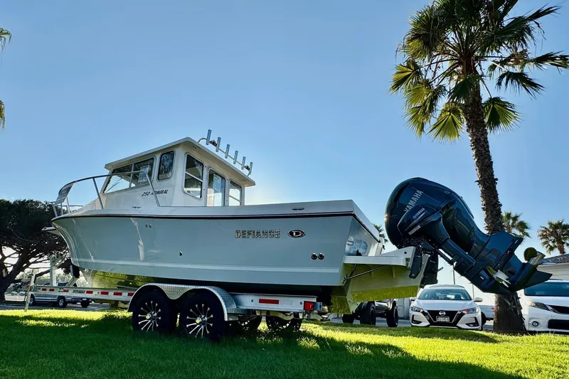 Slide: The Image of 2025 Defiance Admiral 250 EX boat on trailer, parked under palm trees. - 10