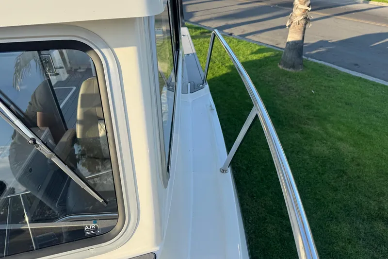 Slide: The Image of 2025 Defiance Admiral 250 EX boat exterior with railing and window view. - 104