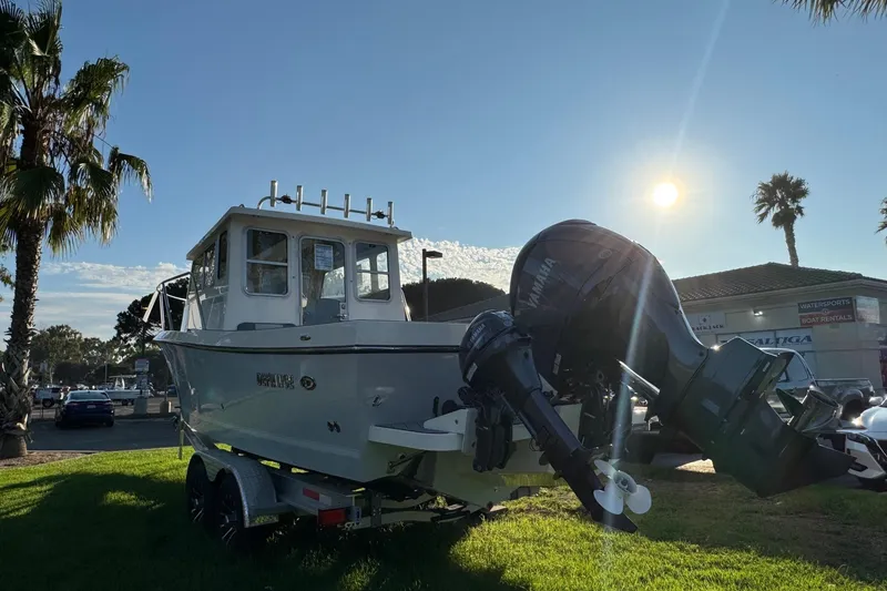 Slide: The Image of 2025 Defiance Admiral 250 EX boat on trailer, sunny day, palm trees in background. - 12