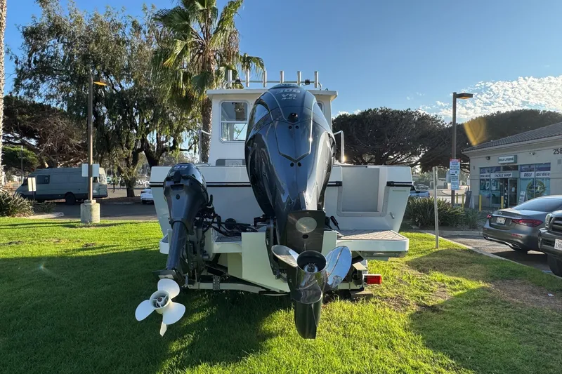 Slide: The Image of 2025 Defiance Admiral 250 EX boat with dual outboard motors on grassy area. - 14