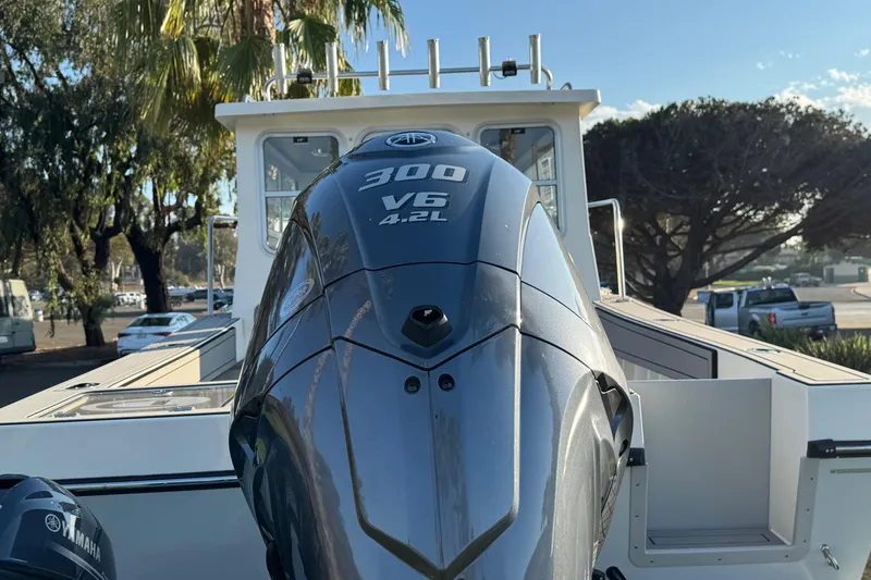 Slide: The Image of 2025 Defiance Admiral 250 EX boat with Yamaha 300 V6 engine, parked outdoors. - 15