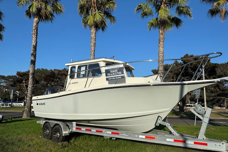 Slide: The Image of 2025 Defiance Admiral 250 EX boat on trailer, surrounded by palm trees. - 2