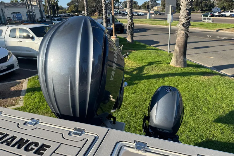 Slide: The Image of Outboard motors on a 2025 Defiance Admiral 250 EX boat, parked near palm trees. - 32