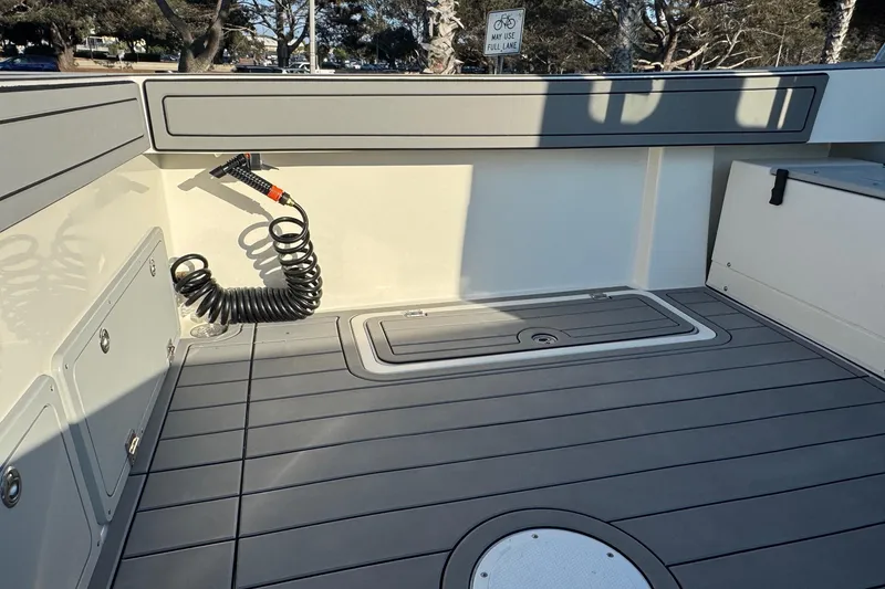 Slide: The Image of 2025 Defiance Admiral 250 EX boat deck with storage compartments and coiled hose. - 39