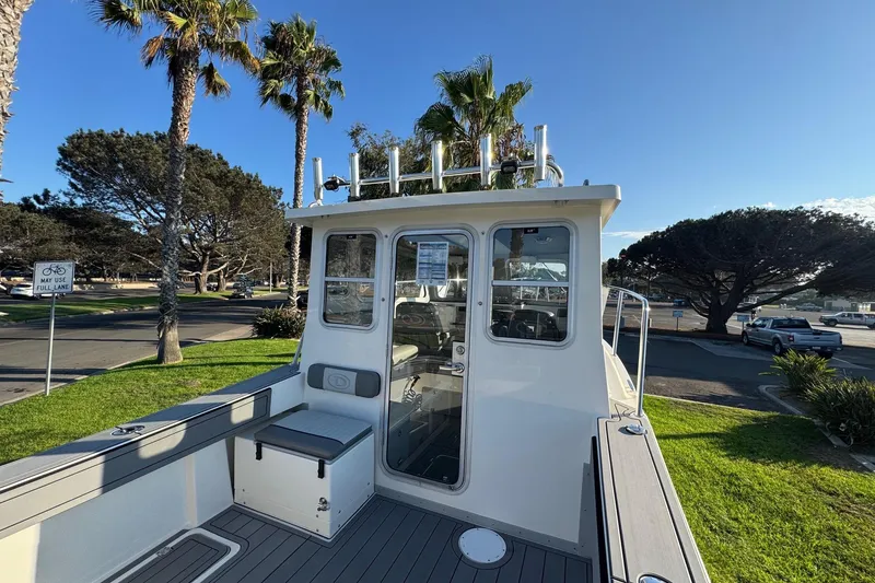 Slide: The Image of 2025 Defiance Admiral 250 EX boat docked near palm trees under clear blue sky. - 41
