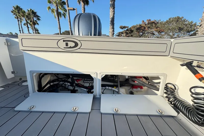 Slide: The Image of 2025 Defiance Admiral 250 EX boat deck with open storage compartments and visible wiring. - 50