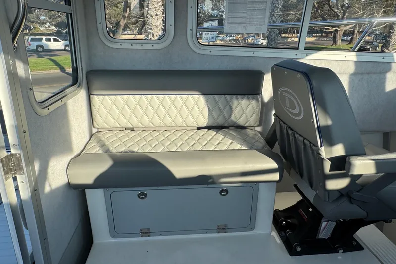Slide: The Image of Interior of 2025 Defiance Admiral 250 EX boat with cushioned seating and windows. - 56