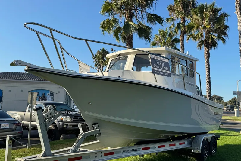 Slide: The Image of 2025 Defiance Admiral 250 EX boat on trailer, parked near palm trees. - 6