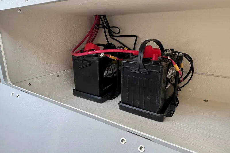 Slide: The Image of 2025 Defiance Admiral 250 EX boat battery compartment with dual marine batteries. - 60