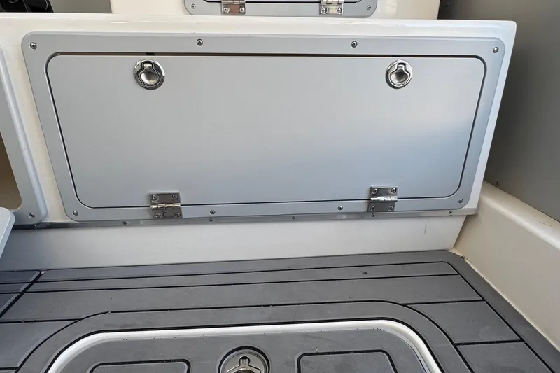 Slide: The Image of 2025 Defiance Admiral 250 EX boat storage compartment with secure latches and non-slip flooring. - 69