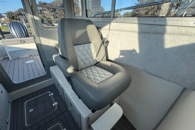 Slide: The Image of Captain's chair in 2025 Defiance Admiral 250 EX boat interior, featuring quilted upholstery. - 74