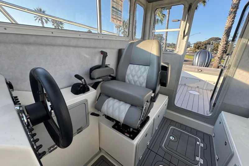 Slide: The Image of Interior of 2025 Defiance Admiral 250 EX boat, featuring steering wheel and captain's chair. - 75