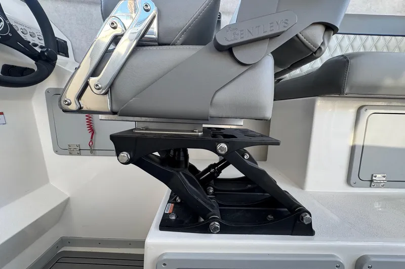 Slide: The Image of Captain's chair on 2025 Defiance Admiral 250 EX boat, featuring adjustable seat mechanism. - 77