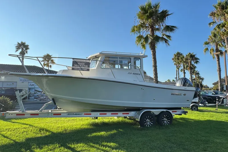 Slide: The Image of 2025 Defiance Admiral 250 EX boat on trailer, displayed outdoors with palm trees. - 8