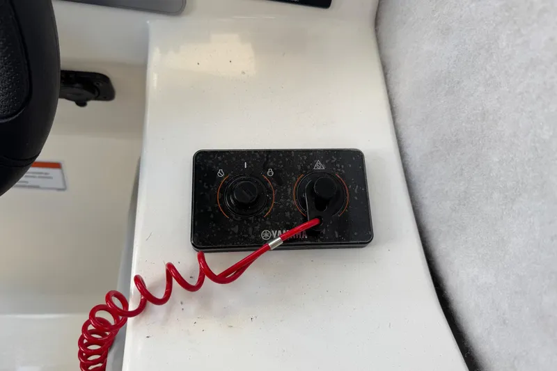 Slide: The Image of Control panel with red coiled cord on 2025 Defiance Admiral 250 EX boat. - 81