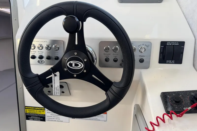 Slide: The Image of Steering wheel and controls of 2025 Defiance Admiral 250 EX boat cockpit. - 82