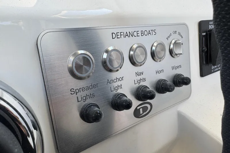 Slide: The Image of Control panel of 2025 Defiance Admiral 250 EX boat with various switches. - 85