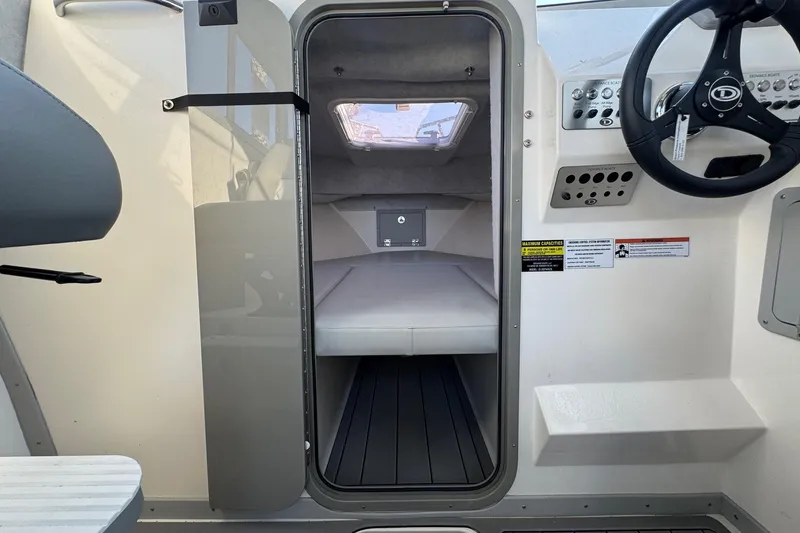 Slide: The Image of Interior view of 2025 Defiance Admiral 250 EX boat cabin with steering wheel and controls. - 86