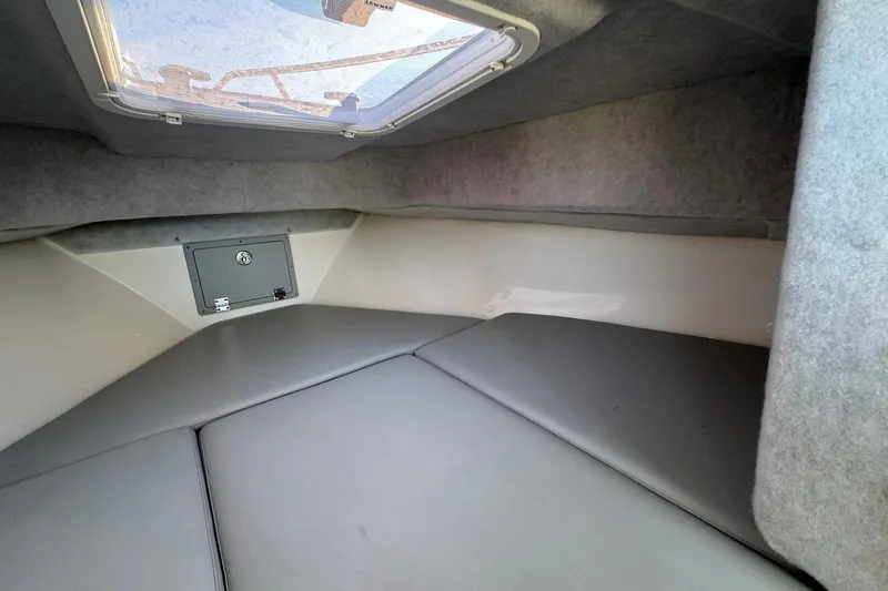 Slide: The Image of Interior cabin of 2025 Defiance Admiral 250 EX boat, featuring cushioned seating and overhead hatch. - 89