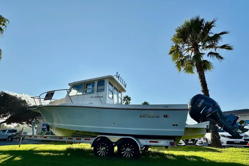 Slide: The Image of 2025 Defiance Admiral 250 EX boat on trailer, sunny day, palm trees in background. - 9