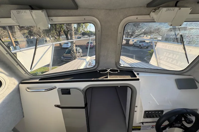 Slide: The Image of Interior view of 2025 Defiance Admiral 250 EX boat, showcasing dashboard and windows. - 91