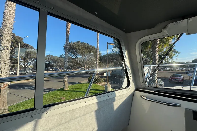 Slide: The Image of Interior view from 2025 Defiance Admiral 250 EX boat, showcasing window and outdoor scenery. - 93