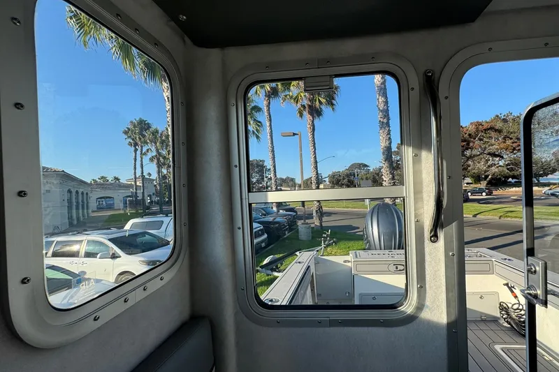 Slide: The Image of Interior view of 2025 Defiance Admiral 250 EX boat, showing windows and outdoor scenery. - 95