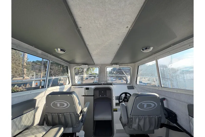Slide: The Image of Interior of 2025 Defiance Admiral 250 EX boat, featuring helm and seating. - 97